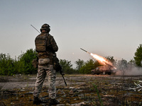 A serviceman from the Steppe Wolves all-volunteer unit is standing near a pickup equipped with Grad rocket launch tubes, which were captured...