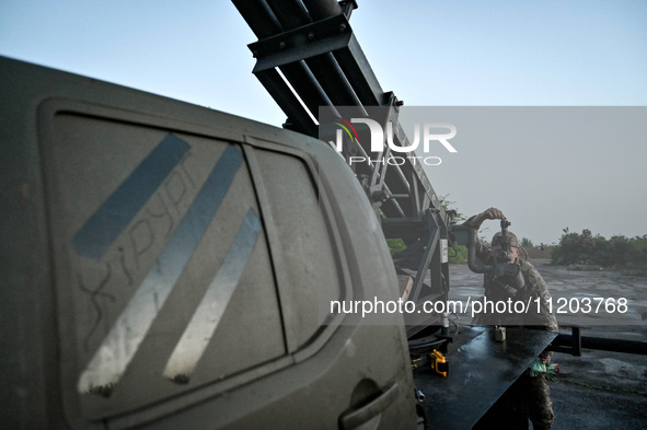 A serviceman from the Steppe Wolves all-volunteer unit is looking through a sighting device installed on Grad rocket launch tubes, which wer...