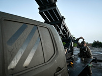 A serviceman from the Steppe Wolves all-volunteer unit is looking through a sighting device installed on Grad rocket launch tubes, which wer...