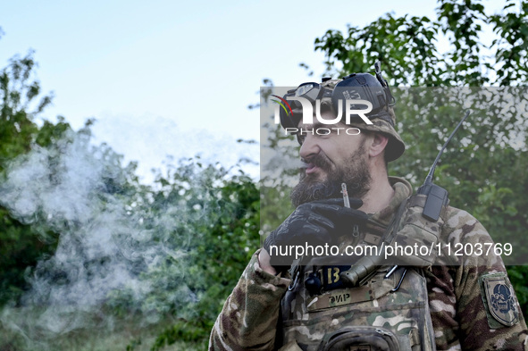 A serviceman from the Steppe Wolves all-volunteer unit is smoking a cigarette in the Zaporizhzhia Region, southeastern Ukraine, on April 27,...