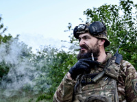 A serviceman from the Steppe Wolves all-volunteer unit is smoking a cigarette in the Zaporizhzhia Region, southeastern Ukraine, on April 27,...