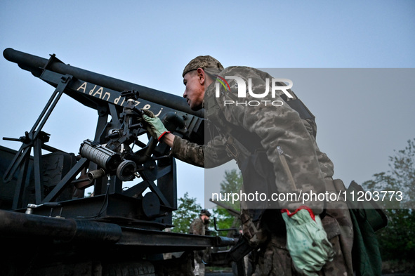 A serviceman from the Steppe Wolves all-volunteer unit is looking through a sighting device installed on Grad rocket launch tubes, which wer...