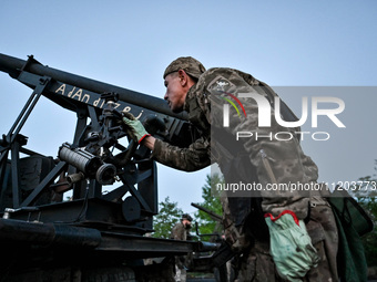 A serviceman from the Steppe Wolves all-volunteer unit is looking through a sighting device installed on Grad rocket launch tubes, which wer...