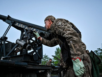 A serviceman from the Steppe Wolves all-volunteer unit is looking through a sighting device installed on Grad rocket launch tubes, which wer...