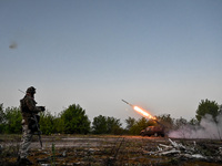 A serviceman from the Steppe Wolves all-volunteer unit is standing near a pickup equipped with Grad rocket launch tubes, which were captured...