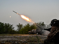 A serviceman from the Steppe Wolves all-volunteer unit is standing near a pickup equipped with Grad rocket launch tubes, which were captured...