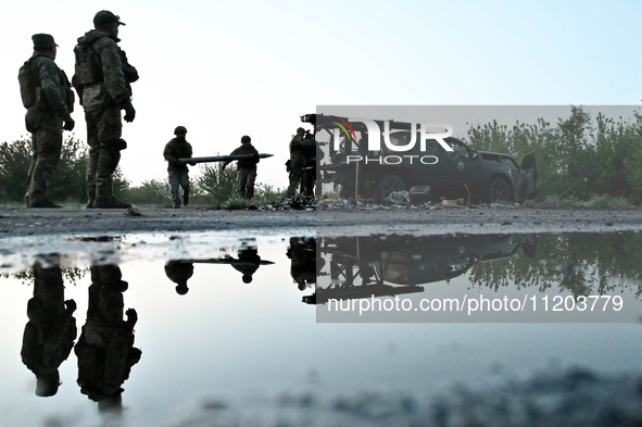 Servicemen of the Steppe Wolves all-volunteer unit are loading Grad rocket launch tubes that they captured from Russian troops and a sightin...