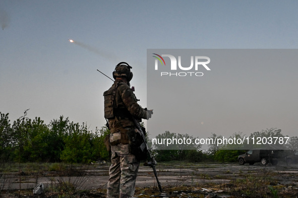 A serviceman from the Steppe Wolves all-volunteer unit is standing near a pickup equipped with Grad rocket launch tubes, which were captured...