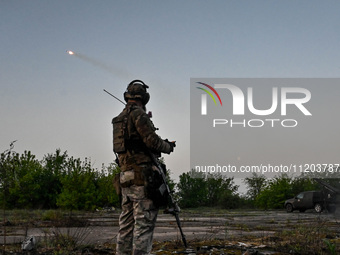 A serviceman from the Steppe Wolves all-volunteer unit is standing near a pickup equipped with Grad rocket launch tubes, which were captured...