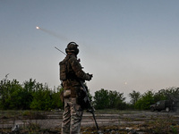 A serviceman from the Steppe Wolves all-volunteer unit is standing near a pickup equipped with Grad rocket launch tubes, which were captured...