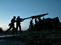 Servicemen of the Steppe Wolves all-volunteer unit are loading Grad rocket launch tubes, which were captured from Russian troops, and a sigh...