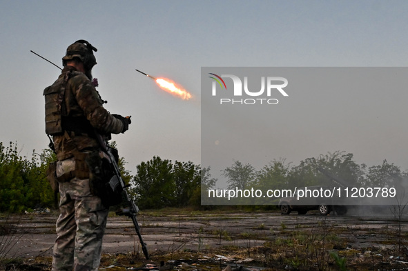 A serviceman from the Steppe Wolves all-volunteer unit is standing near a pickup equipped with Grad rocket launch tubes, which were captured...