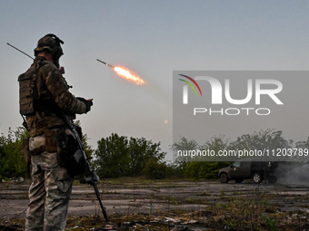 A serviceman from the Steppe Wolves all-volunteer unit is standing near a pickup equipped with Grad rocket launch tubes, which were captured...