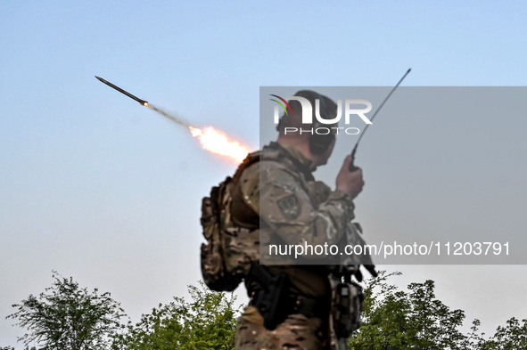 A serviceman from the Steppe Wolves all-volunteer unit is standing near a pickup equipped with Grad rocket launch tubes, which were captured...