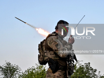 A serviceman from the Steppe Wolves all-volunteer unit is standing near a pickup equipped with Grad rocket launch tubes, which were captured...