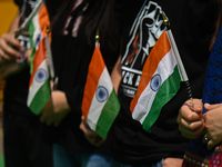 Members of the Kuki-Zo community are holding Indian national flags during a protest against the violent clashes that began last year on May...