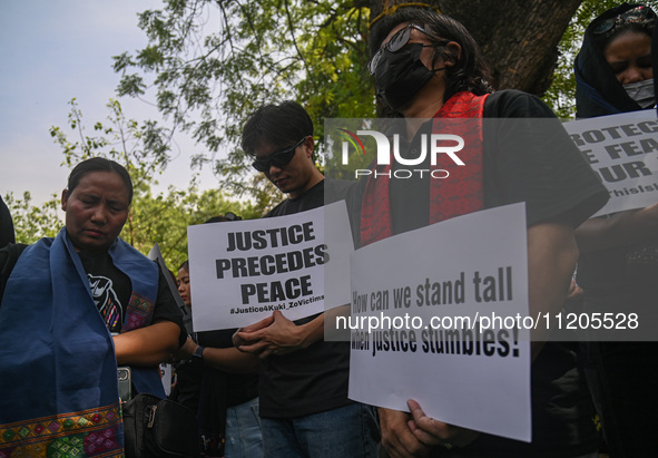 Members of the Kuki-Zo community are holding placards in a protest against the violent clashes that began last year on May 3, 2023, between...