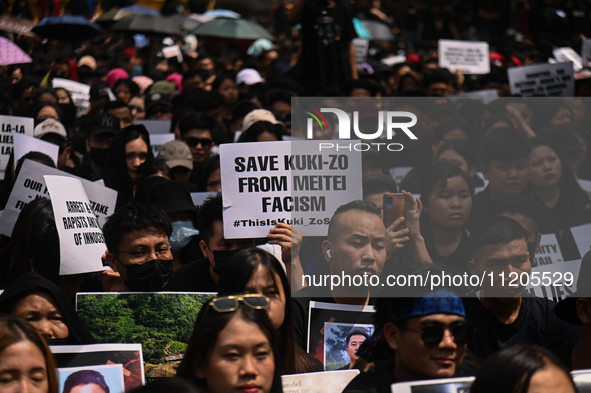 Members of the Kuki-Zo community are holding placards in a protest against the violent clashes that began last year on May 3, 2023, between...