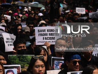 Members of the Kuki-Zo community are holding placards in a protest against the violent clashes that began last year on May 3, 2023, between...