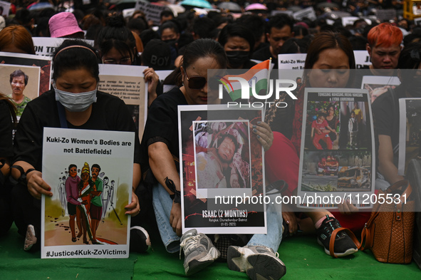 Members of the Kuki-Zo community are holding placards in a protest as they mourn the killings from the violent clashes that began last year...