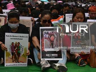 Members of the Kuki-Zo community are holding placards in a protest as they mourn the killings from the violent clashes that began last year...