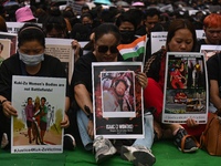 Members of the Kuki-Zo community are holding placards in a protest as they mourn the killings from the violent clashes that began last year...