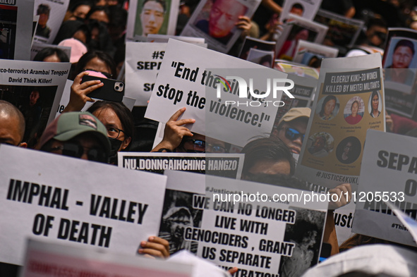 Members of the Kuki-Zo community are holding placards in a protest against the violent clashes that began last year on May 3, 2023, between...