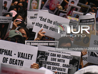 Members of the Kuki-Zo community are holding placards in a protest against the violent clashes that began last year on May 3, 2023, between...