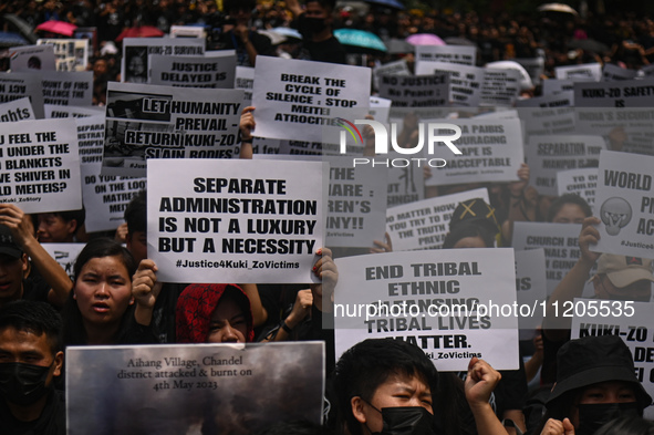 Members of the Kuki-Zo community are holding placards in a protest against the violent clashes that began last year on May 3, 2023, between...