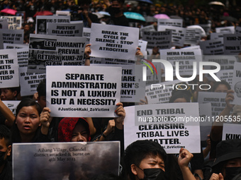 Members of the Kuki-Zo community are holding placards in a protest against the violent clashes that began last year on May 3, 2023, between...