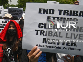 Members of the Kuki-Zo community are holding placards in a protest against the violent clashes that began last year on May 3, 2023, between...