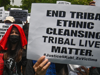 Members of the Kuki-Zo community are holding placards in a protest against the violent clashes that began last year on May 3, 2023, between...