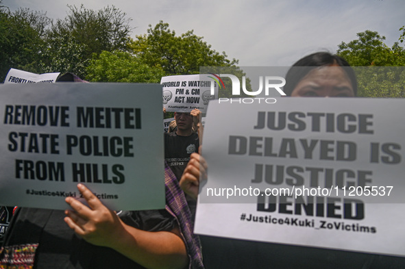 Members of the Kuki-Zo community are holding placards in a protest against the violent clashes that began last year on May 3, 2023, between...