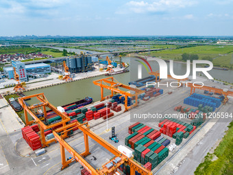 Workers are carrying out loading and unloading operations at the container terminal of Xinghua Port in East China's Jiangsu province, on May...