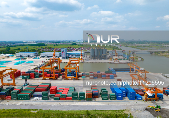 Workers are carrying out loading and unloading operations at the container terminal of Xinghua Port in East China's Jiangsu province, on May...