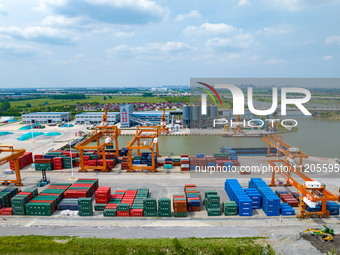 Workers are carrying out loading and unloading operations at the container terminal of Xinghua Port in East China's Jiangsu province, on May...