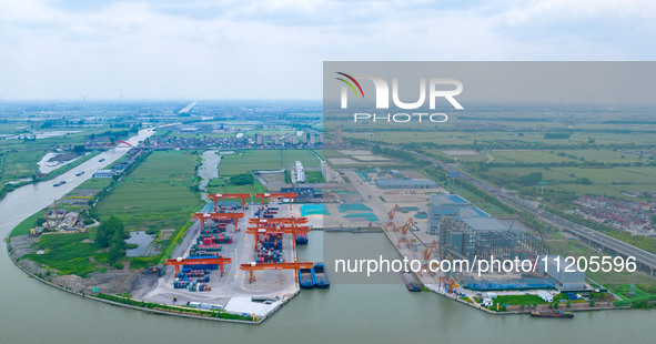 Workers are carrying out loading and unloading operations at the container terminal of Xinghua Port in East China's Jiangsu province, on May...