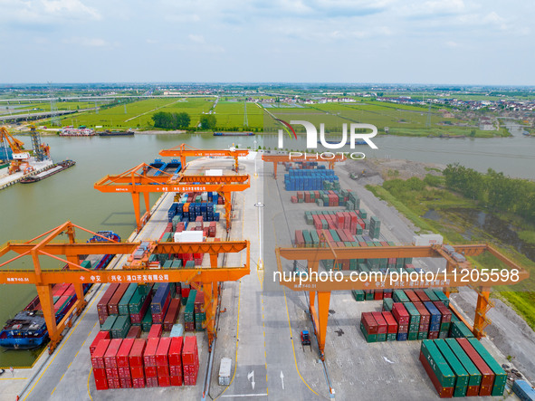 Workers are carrying out loading and unloading operations at the container terminal of Xinghua Port in East China's Jiangsu province, on May...