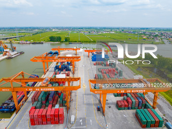 Workers are carrying out loading and unloading operations at the container terminal of Xinghua Port in East China's Jiangsu province, on May...