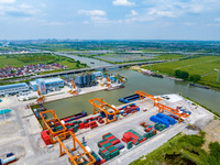 Workers are carrying out loading and unloading operations at the container terminal of Xinghua Port in East China's Jiangsu province, on May...