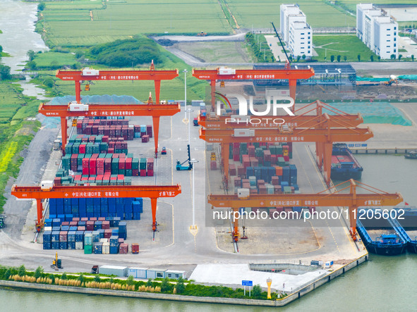 Workers are carrying out loading and unloading operations at the container terminal of Xinghua Port in East China's Jiangsu province, on May...