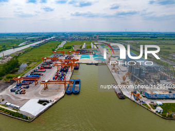 Workers are carrying out loading and unloading operations at the container terminal of Xinghua Port in East China's Jiangsu province, on May...