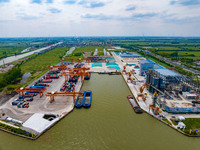 Workers are carrying out loading and unloading operations at the container terminal of Xinghua Port in East China's Jiangsu province, on May...