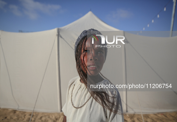 A Palestinian girl is attending a wedding among makeshift tents in Khan Younis, in the southern Gaza Strip, on May 3, 2024, amid the ongoing...