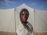 A Palestinian girl is attending a wedding among makeshift tents in Khan Younis, in the southern Gaza Strip, on May 3, 2024, amid the ongoing...