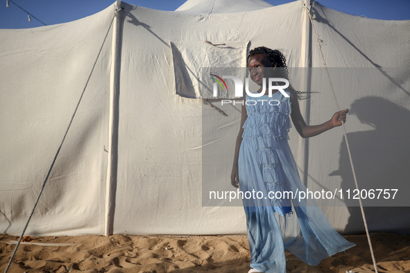 A Palestinian girl is attending a wedding among makeshift tents in Khan Younis, in the southern Gaza Strip, on May 3, 2024, amid the ongoing...