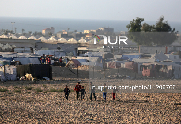 Displaced Palestinians are playing football next to their tents in Khan Younis, in the southern Gaza Strip, on May 3, 2024, amid the ongoing...