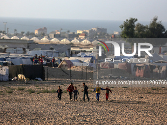 Displaced Palestinians are playing football next to their tents in Khan Younis, in the southern Gaza Strip, on May 3, 2024, amid the ongoing...