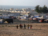 Displaced Palestinians are playing football next to their tents in Khan Younis, in the southern Gaza Strip, on May 3, 2024, amid the ongoing...