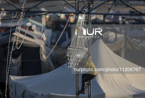 A Palestinian girl is attending a wedding among makeshift tents in Khan Younis, in the southern Gaza Strip, on May 3, 2024, amid the ongoing...